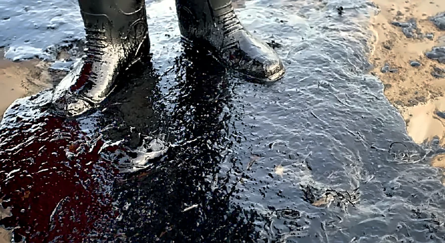 Bottes dans une large flaque d'huile